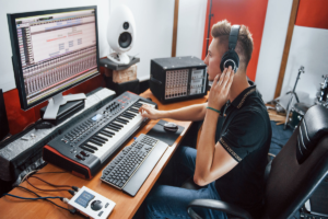 Sound engineer in headphones working and mixing music in the studio_images-1200x800